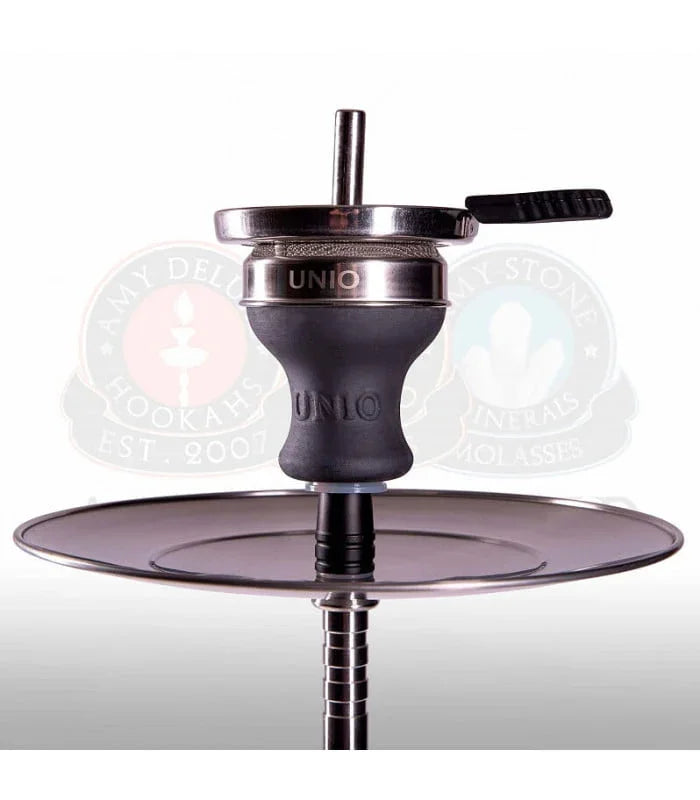 Bowl of dark clay with a metal screen holder and handle on top, set on the steel plate of a hookah.